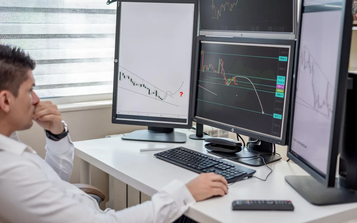 Analyst working across multiple screens tracking reputation signals
